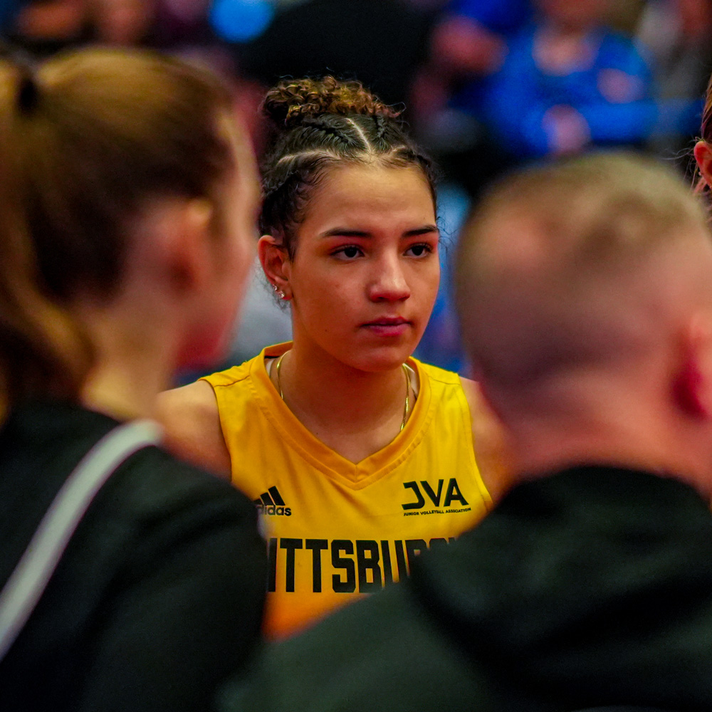 Camdynn listening to her coach in the team huddle